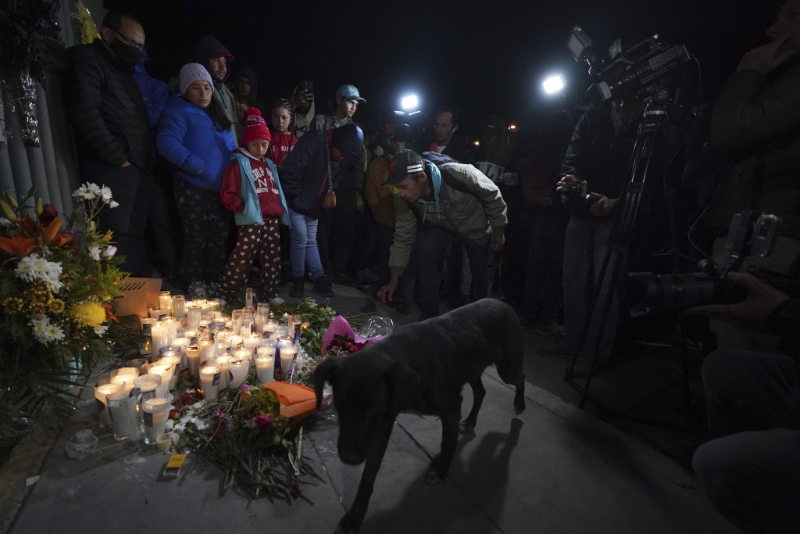 一名移民为墨西哥移民拘留中心发生火灾的受害者点燃蜡烛悼念。 AP