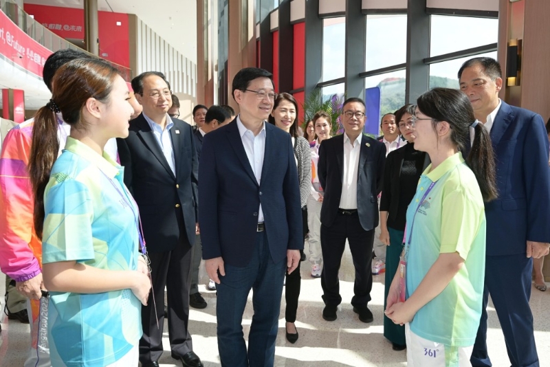 李家超（左三）与杭州第19届亚洲运动会志愿者交流。 政府新闻处