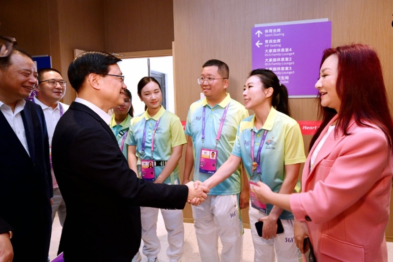李家超（前排左二）与杭州第19届亚洲运动会志愿者交流。 政府新闻处