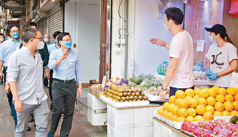 ■李家超向沿路的店铺东主打招呼。