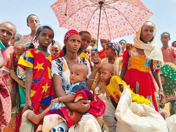 埃塞俄比亚提格雷州的妇女和儿童，在世界粮食计划署的粮食分发点排队等候派粮。