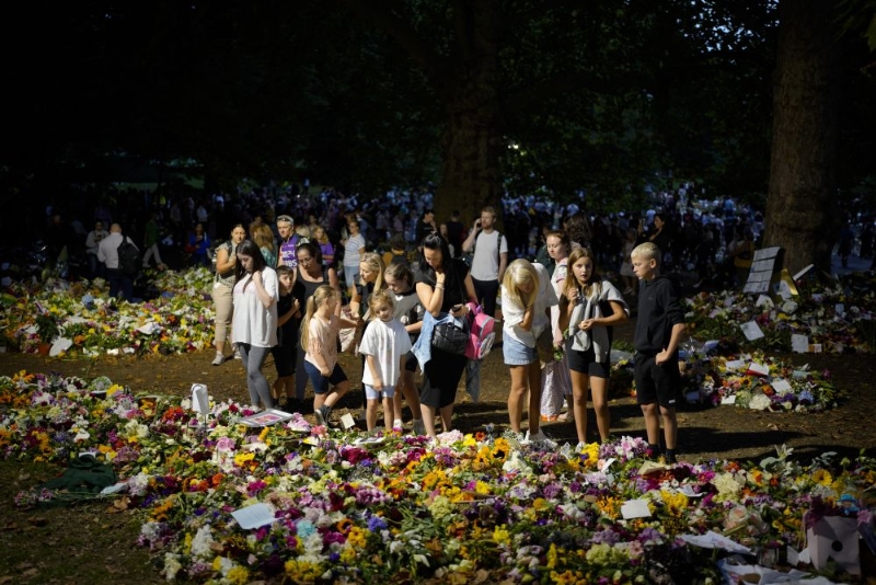 民眾聚集在倫敦白金漢宮附近的綠色公園為英女皇伊利莎白二世獻花。AP