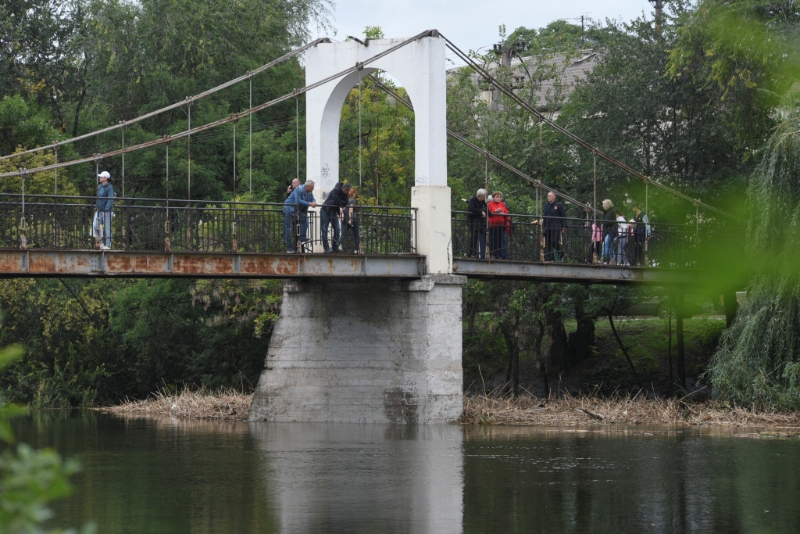 在烏克蘭克里維里赫，一座水霸被俄羅斯導彈擊中後，人們站在因胡萊茨河上的一座橋上。路透社