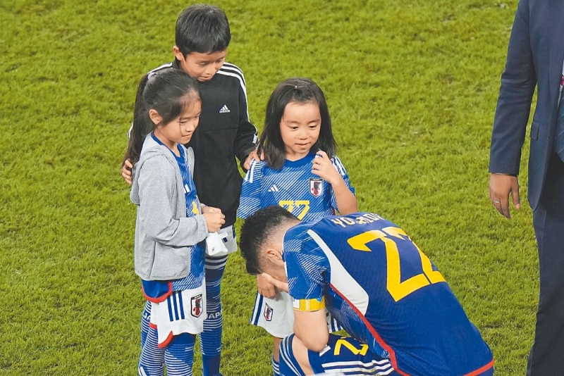 日本PK戰不敵克羅埃西亞，無緣卡達世足賽8強，隊長吉田麻也在賽後痛哭落淚，同穿22號球衣的女兒（見圖，站立者右一）還上前安慰，現場觀戰的日本球迷也哭紅了眼眶。（美聯社）