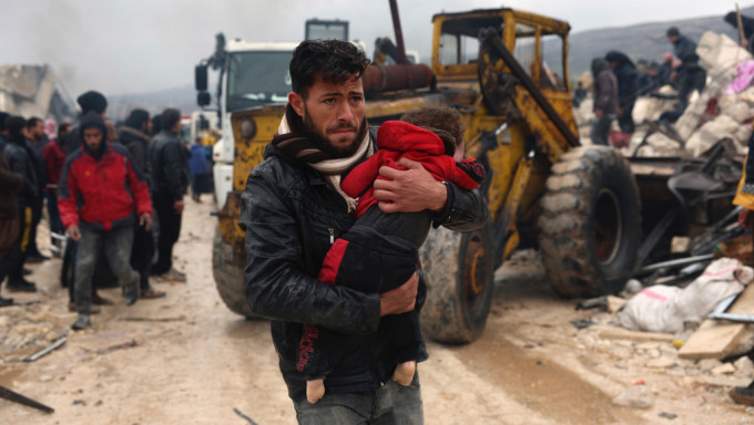 敍利亞伊德利卜一名男子緊抱在地震中遇難的孩子。 美聯社
