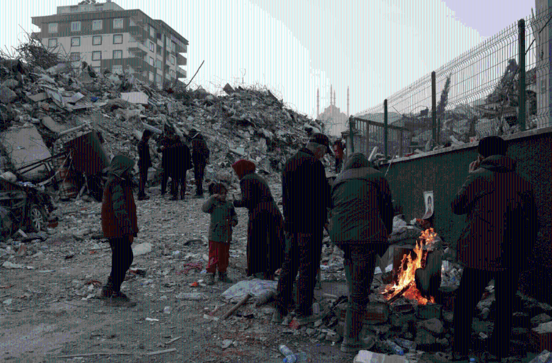 土耳其災民站在被毀房屋廢墟附近的火堆旁取暖。路透社