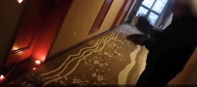 视频显示，一名疑似死者亲人的男子头上缠着白布，在酒店的走廊上，手拿锣钹打击。 网图
