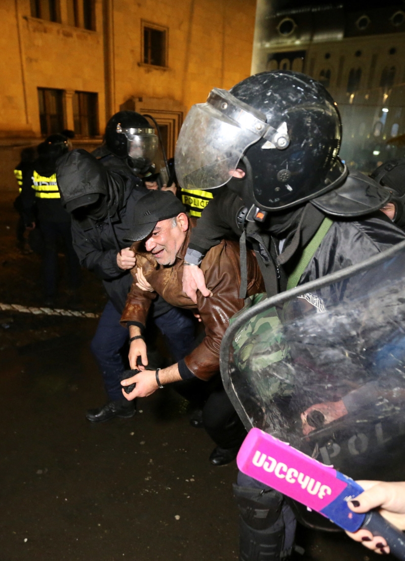 格魯吉亞大規模示威反對外國代理人法案，警方制服一名示威者。 路透社