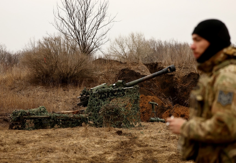 2023年3月8日，在巴赫穆特（Bakhmut）前线，一名乌军正等候命令发射M119榴弹炮。 路透社