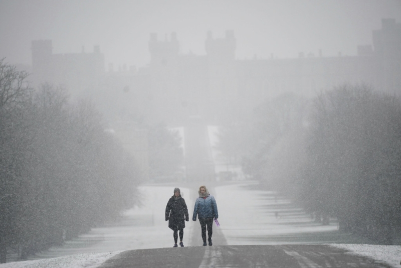人們冒雪沿著通往伯克郡溫莎城堡的 Long Walk 上行走。AP