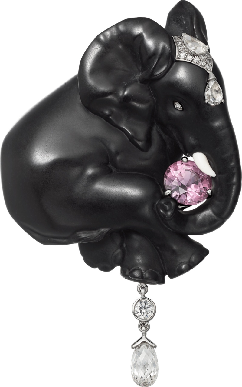 Éléphant Noir胸針，這隻黑色大象的身軀用上石化木蘭花木製作，並以白色黃金鑲嵌1顆圓形馬達加斯加粉紅色藍寶石（1.52卡）、梨形鑽石、水滴形切割鑽石及圓形明亮式切割鑽石。