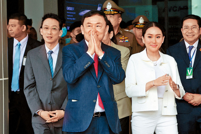 他信（中）上周二结束流亡回国，抵达曼谷廊曼机场，子女到场迎接