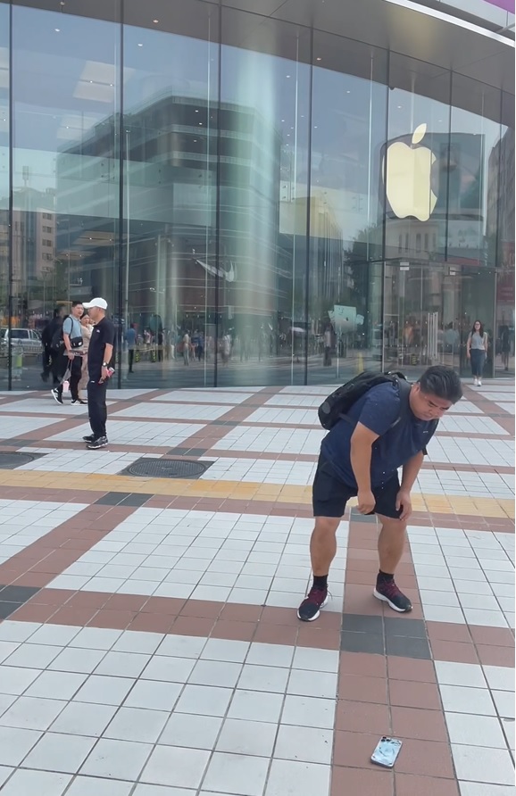 刘金在苹果店外反覆把其iPhone掷落地。影片截图