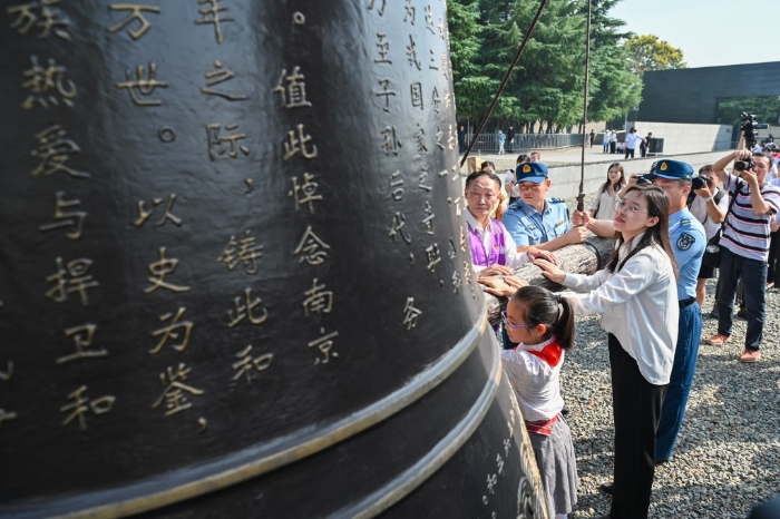 民众在南京大屠杀遇难同胞纪念馆撞响和平大钟。