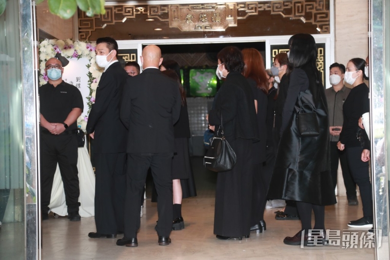 刘德华背着殡仪馆内的传媒，似刻意用人墙包围着女儿及太太尽量避开传媒镜头。