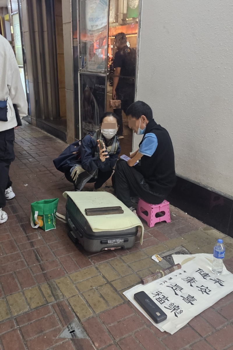女途人出言安慰在旺角摆卖的残障艺术家。 徐裕民摄