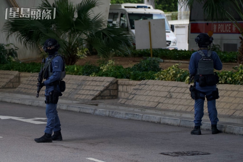 警员荷枪实弹在庭外戒备。