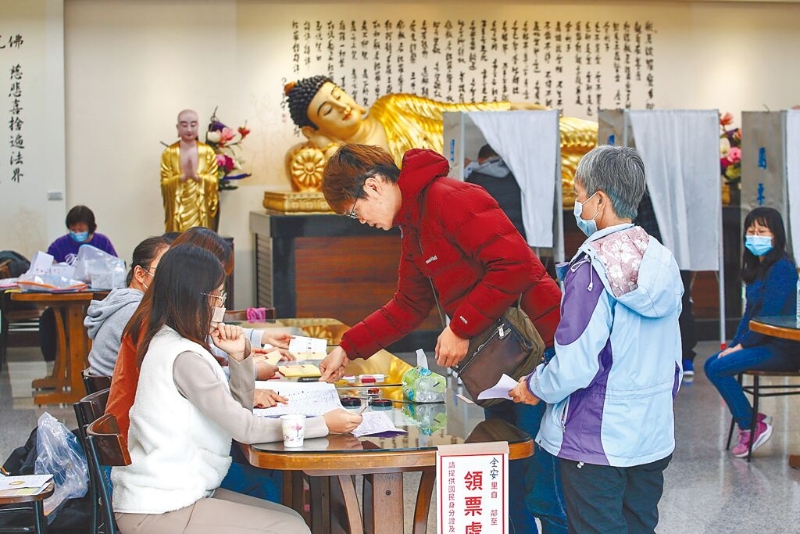 选民在新庄区佛光山择善寺投开票所如来卧佛前投票。