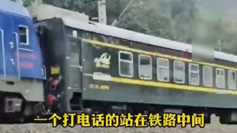 云南有男子在铁路轨上打电话，令火车急停6分钟。 影片截图