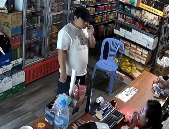 胡春晓失踪前，其中一名戴帽的男子走入店内。