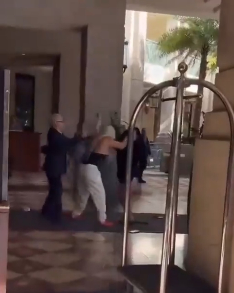 影片显示两名女子在酒店外拉扯，白裤tubetop（背心）女扯头发兼挥拳。