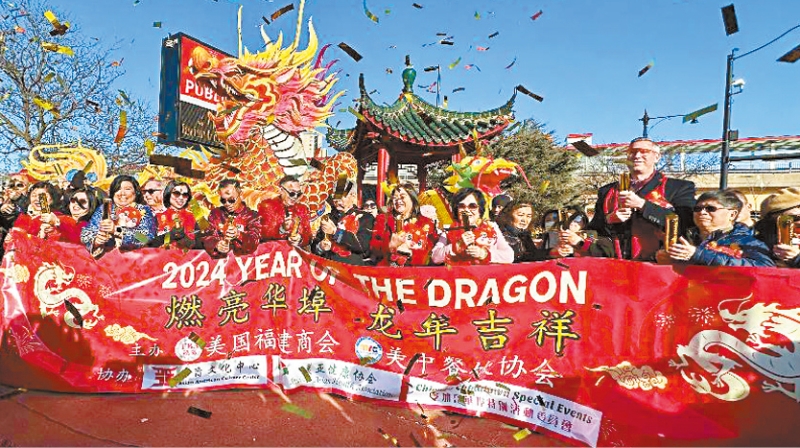 燃亮华埠龙年吉祥典礼中，嘉宾们燃放花炮，漫天飞舞的金色花炮象征着华埠美好的未来。 梁敏育摄