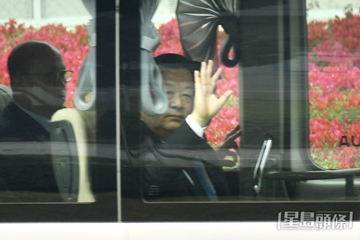 夏宝龙向在场传媒挥手。中联办主任郑雁雄（左）亦在车上