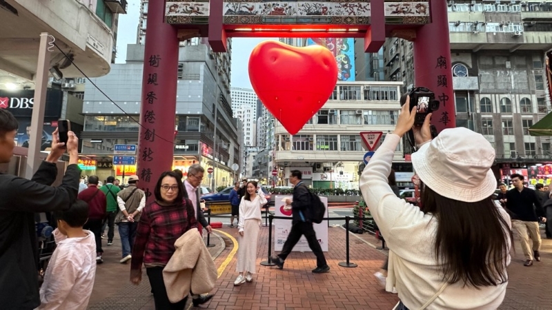 不少市民举机将庙街牌楼与红心摄入镜头内。