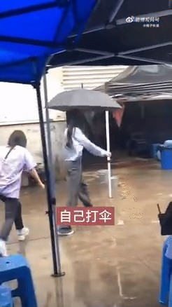 杨幂自己打伞。