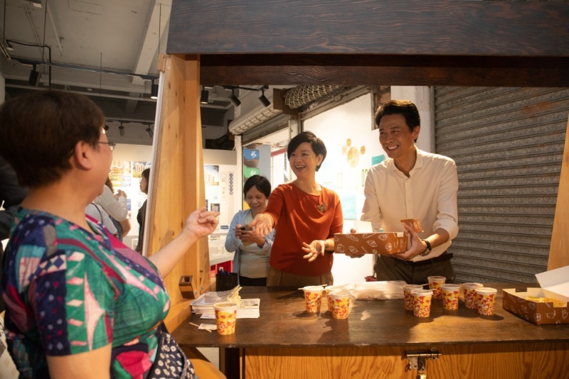 何永贤等人在的茶档道具摊位向街坊派奶茶、蛋挞等。