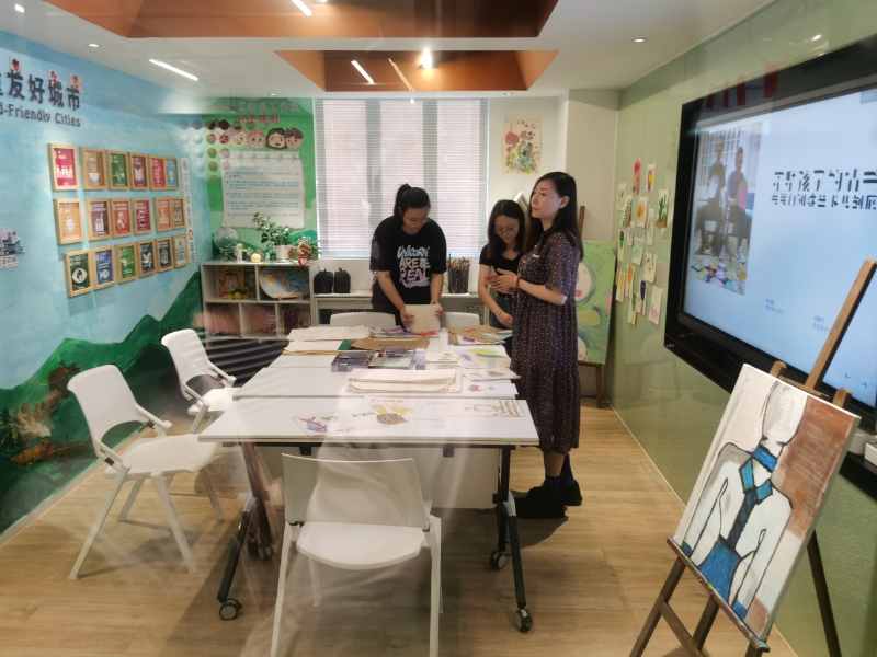 儿童友好城市大湾区小小议事员工作室内，工作人员正在整理自闭症儿童的画作。