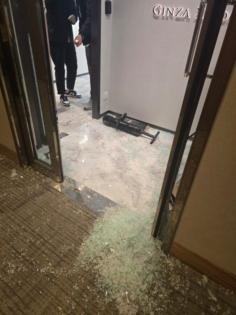 门口遗下大堆玻璃碎及爆门工具。