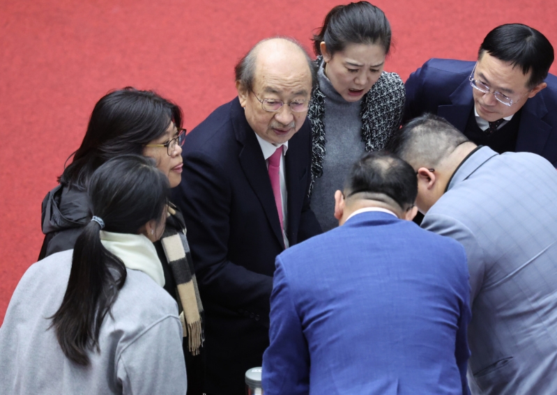 图为民进党团总召柯建铭（中）与党籍立委讨论议事内容。